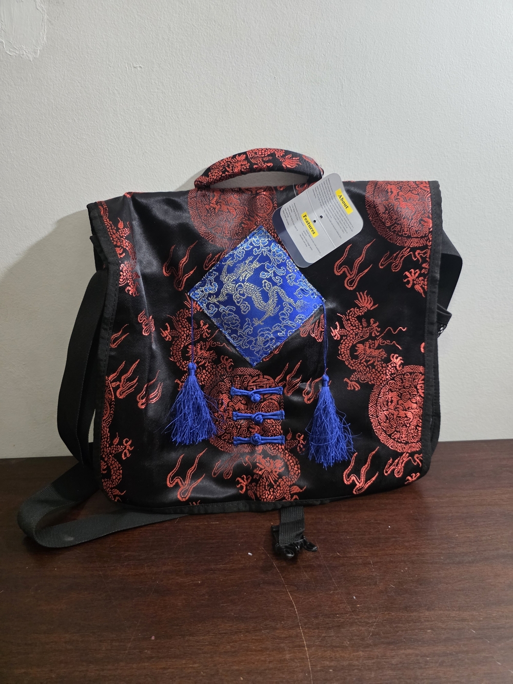 Black and Red Dragon-Print Crossbody Bag with Blue Tassel Accent